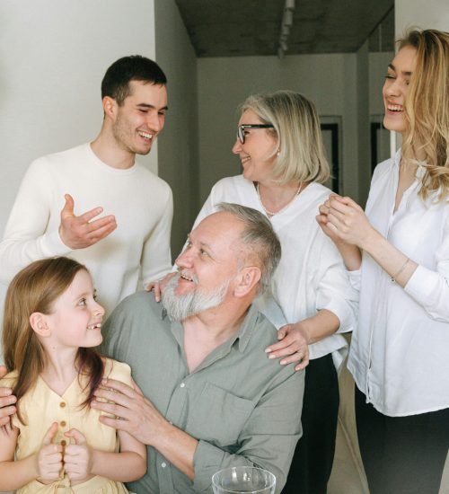 A joyful family gathering indoors celebrating a significant milestone with smiles and conversation.